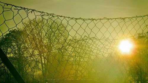 View of chainlink fence against sky during sunset