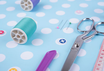 Close-up of thread spool and scissors on table