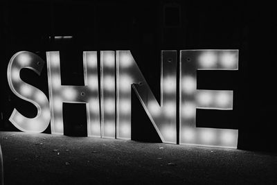 Close-up of illuminated text on wall