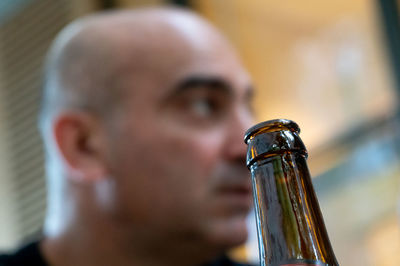 Close-up of beer bottle with man