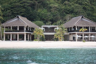 House by sea against trees