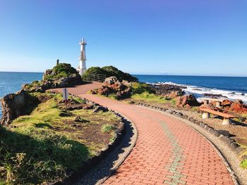 Scenic view of sea and buildings against clear blue sky