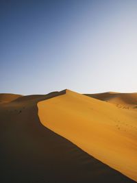 Sand dune against clear sky