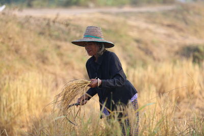 Side view of man wearing hat on field