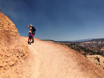 Full length of man riding motorcycle on landscape against sky