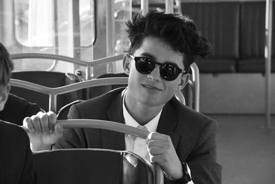 Portrait of teenage boy wearing sunglasses sitting in bus