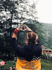 Rear view of woman photographing on field