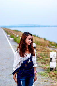 Smiling young woman standing on road