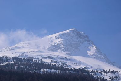 Scenic view of snowcapped mountains against blue sky