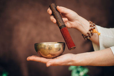 Cropped hands of woman holding mortar and pestle