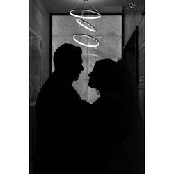 Silhouette couple standing against wall