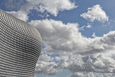 Low angle view of modern building against cloudy sky