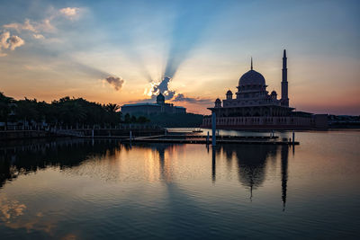 Putra mosque by lake against sky during sunset