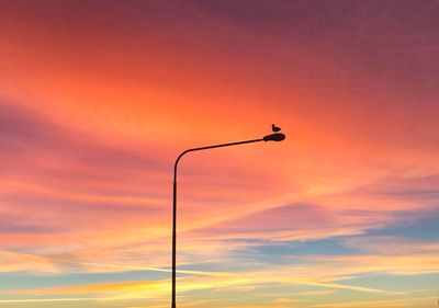 Low angle view of street light against orange sky