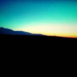 Scenic view of landscape against clear sky at sunset