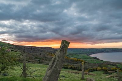 Scenic view of field against sky at sunset