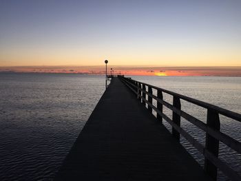 Pier on sea at sunset