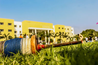 Kite spool on grassy field against building