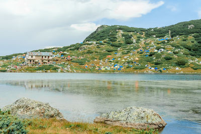 Scenic view of townscape by mountain against sky