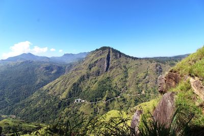 Scenic view of mountains against blue sky