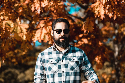 Man wearing sunglasses while standing against trees
