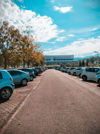 Cars parked on road against sky in city