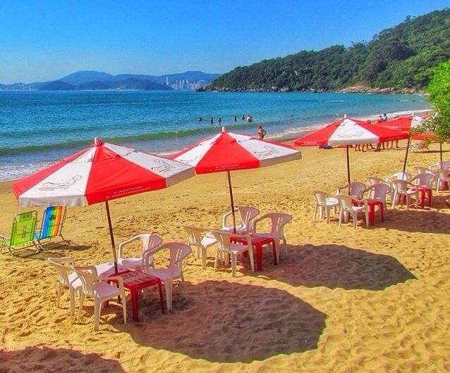 beach, sand, sea, water, chair, beach umbrella, clear sky, lounge chair, shore, absence, deck chair, vacations, tranquility, sunshade, relaxation, mountain, tranquil scene, parasol, sunlight, empty