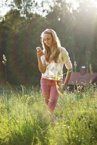 Girl with cell phone on meadow