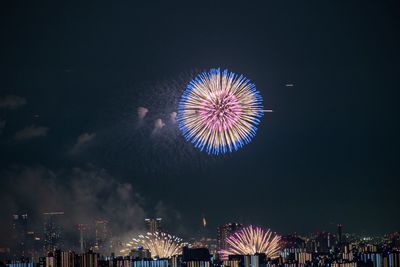 Low angle view of fireworks against sky at night