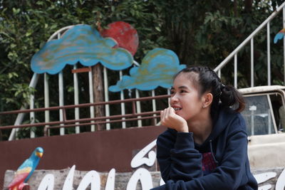 Boy looking away while sitting outdoors