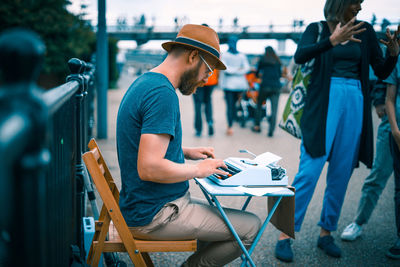 Side view of man using mobile phone in city