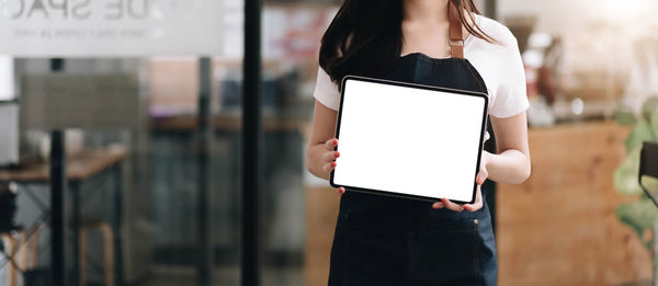 Midsection of woman holding smart phone