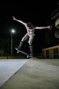 Young white man jumping on his skateboard