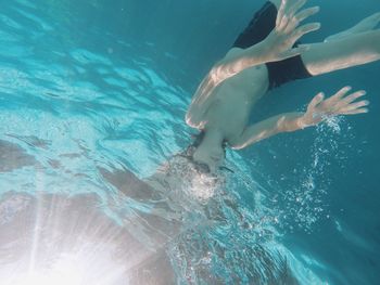 High angle view of shirtless boy swimming in pool