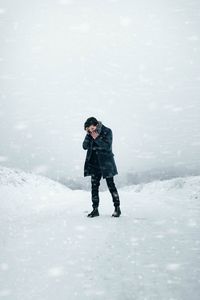 Full length of man standing on snow covered field