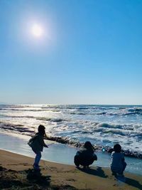 People on beach against sky