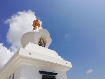 Low angle view of cross against building against sky