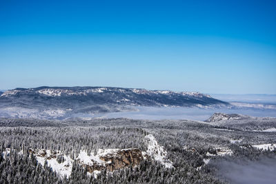 Scenic view of snowcapped mountains against clear blue sky