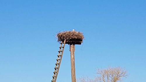 Low angle view of traditional windmill against clear blue sky