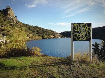 Scenic view of lake by mountains against sky