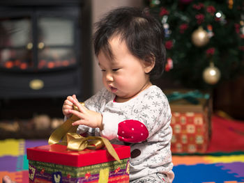 Cute baby girl with christmas gift at home