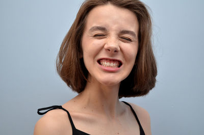 Frustrated girl making a face against white background