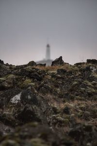 Low angle view of lighthouse amidst buildings against sky