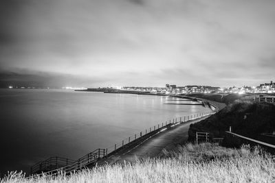 A man with a torch lights the way across the promenade in westgate-on-sea, near margate.