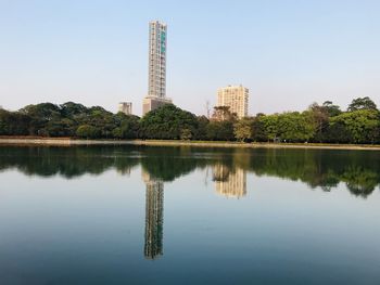 Reflection of buildings and trees in lake against sky