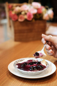 Close-up of hand holding ice cream in bowl