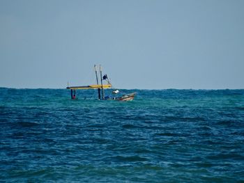 Sailboat in sea against clear sky