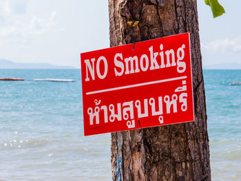 Close-up of warning sign on wooden post