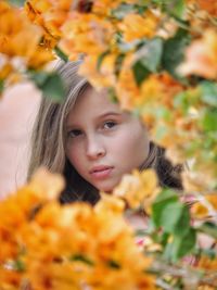 Close-up of young woman with yellow flowers