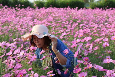 Portrait of woman by pink flowering plants